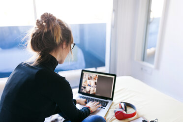 Frau auf dem Bett mit Laptop - VABF01113