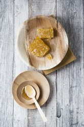 Honeycombs and honey on wooden plates - MYF01869