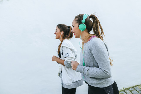 Junge Frauen joggen auf der Straße, lizenzfreies Stockfoto