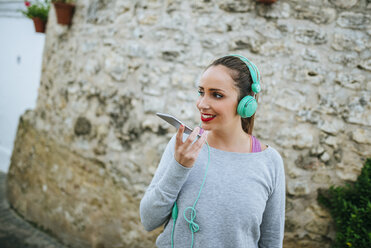 Young woman with headphones sending a voice message - KIJF01235