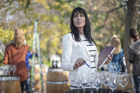 Verkäuferin bei einer Weinverkaufsveranstaltung, die eine Weinstation vorbereitet, lizenzfreies Stockfoto