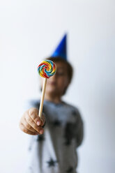 Hand of little boy holding lollipop, close-up - VABF01145