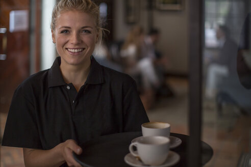 Porträt einer lächelnden Kellnerin in einem Cafe - ZEF12874