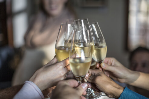 Group of friends raising a toast with champagne glasses - ZEF12876