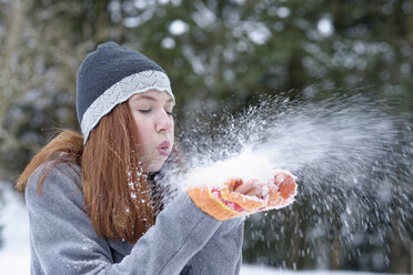Teenager-Mädchen bläst sich den Schnee aus den Händen - LBF01562