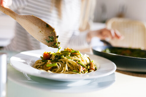 Young woman serving vegan pasta dish - VABF01186