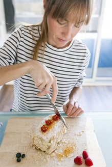 Junge Frau schneidet veganen Kuchen auf - VABF01195