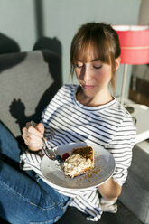 Junge Frau isst ein Stück veganen Kuchen - VABF01198