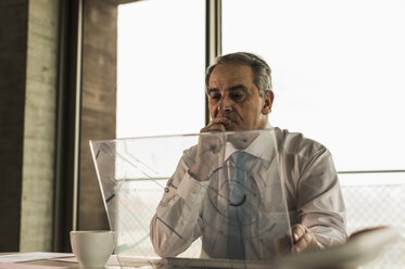 Senior manager in office using futuristic computer - UUF09910