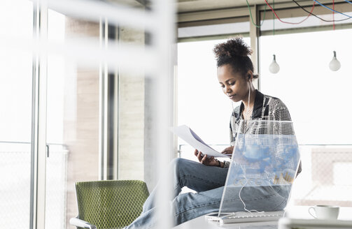 Junge Frau arbeitet im Büro an einem transparenten Computer - UUF09947