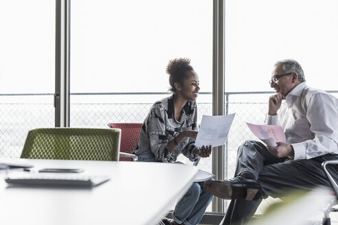 Senior manager discussing documents with young coworker - UUF09964