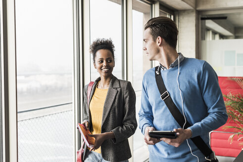 Young business people walking together in office - UUF09975