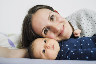 Happy mother lying in bed with her newborn daughter - GEMF01494