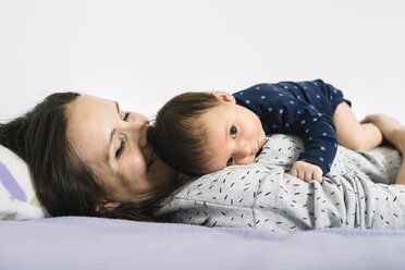 Mutter liegt im Bett und hält ihre neugeborene Tochter - GEMF01495