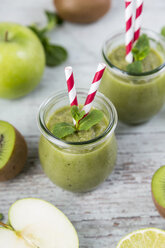 Gass von grünem Smoothie und Zutaten auf Holz - JUNF00858