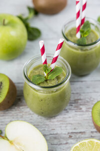 Gass von grünem Smoothie und Zutaten auf Holz - JUNF00858