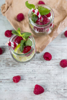 Gläser mit Entgiftungswasser mit Limetten und Himbeeren, dekoriert mit Minzblättern - JUNF00867