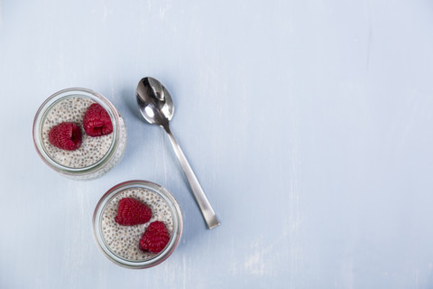 Glass of chia pudding with soya vanilla milk and raspberries stock photo