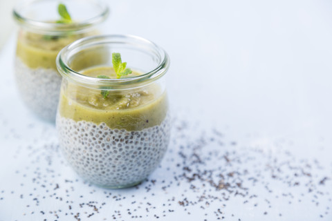 Glass of chia pudding with soya vanilla milk and kiwi mush stock photo