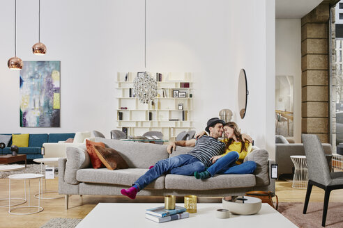 Paar in modernem Möbelhaus testet Couch und ist glücklich - RORF00597