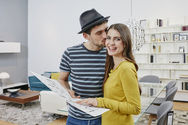 Couple with floor plan choosing furniture in furniture shop - RORF00610
