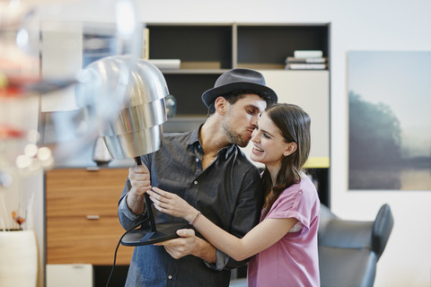Paar im Möbelhaus bei der Auswahl einer Lampe, lizenzfreies Stockfoto