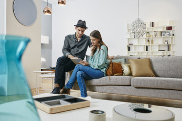 Couple choosing furniture in shop, using digital tablet - RORF00631