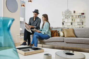 Ein Paar wählt in einem Geschäft Möbel aus, mit Hilfe eines digitalen Tablets - RORF00632