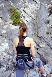 Frau bereitet sich auf das Klettern an einer Felswand vor - LMF00662