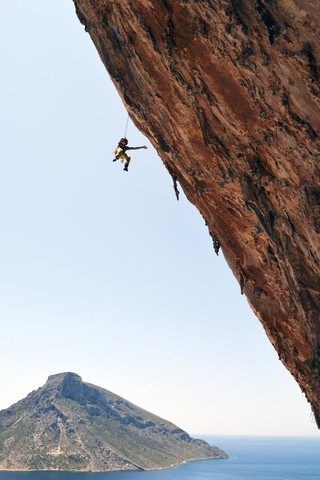 Greece, Kalymnos, climber abseiling in rock wall stock photo