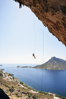 Griechenland, Kalymnos, Kletterer beim Abseilen in der Felswand - LMF00672