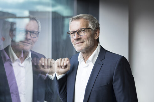 Selbstbewusster Geschäftsmann schaut aus dem Fenster - RBF05613