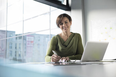 Portrait of smiling businesswoman in office - RBF05634