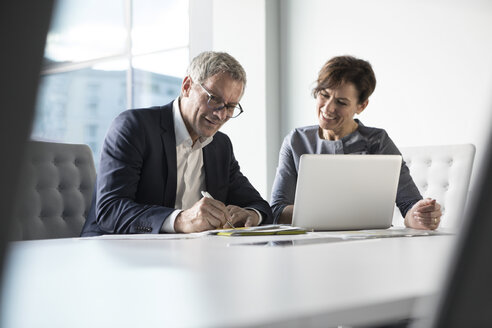 Geschäftsmann und Geschäftsfrau arbeiten zusammen im Büro - RBF05646