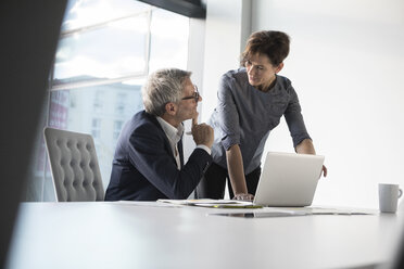 Businessman and businesswoman with laptop in office - RBF05647