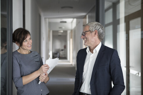 Lächelnder Geschäftsmann und Geschäftsfrau im Büro - RBF05649