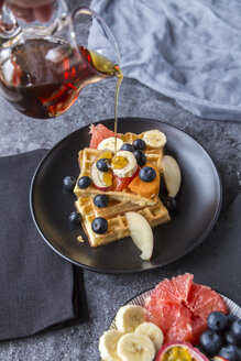 Ahornsirup auf Waffeln mit verschiedenen Früchten gießen - SARF03188