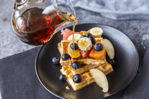 Ahornsirup auf Waffeln mit verschiedenen Früchten gießen - SARF03189