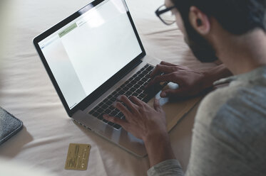 Young man with laptop shopping online - ZOCF00140