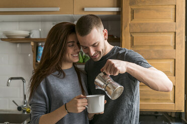 Verliebtes Paar steht in der Küche und trinkt Kaffee - KKAF00450