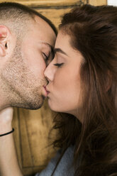 Young couple kissing at home - KKAF00452