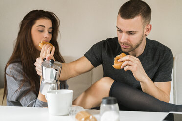 Verliebtes Paar auf der Couch sitzend, beim Frühstück - KKAF00454