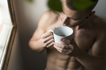 Attractive young man with six pack drinking coffee - KKAF00481