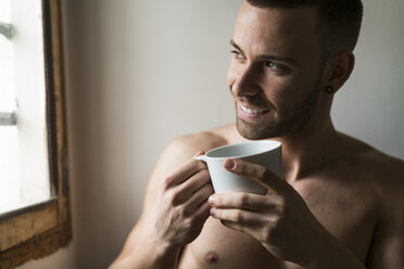 Attractive young amn with six pack drinking coffee - KKAF00483