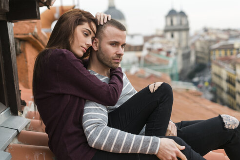 Verliebtes Paar auf dem Dach sitzend, sich küssend und umschwärmend - KKAF00485