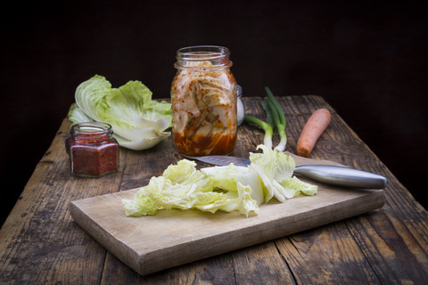 Glas mit Kimchi und Zutaten auf dunklem Holz, lizenzfreies Stockfoto