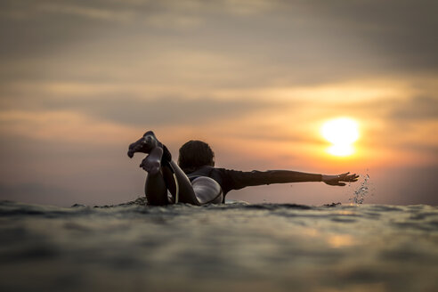 Indonesien, Bali, Surferin im Meer bei Sonnenuntergang - KNTF00639