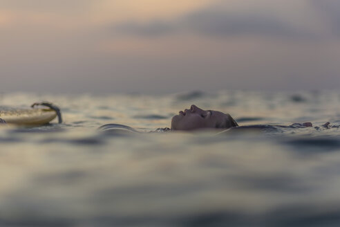 Indonesien, Bali, Surferin im Meer bei Sonnenuntergang - KNTF00643