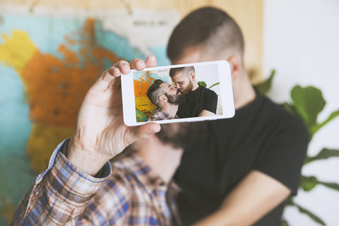 Junges schwules Paar macht ein Selfie mit Smartphone, Nahaufnahme, lizenzfreies Stockfoto