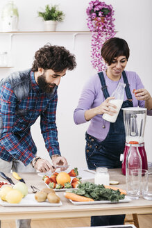 Couple preparing smoothies with fresh fruits and vegetables - JRFF01206